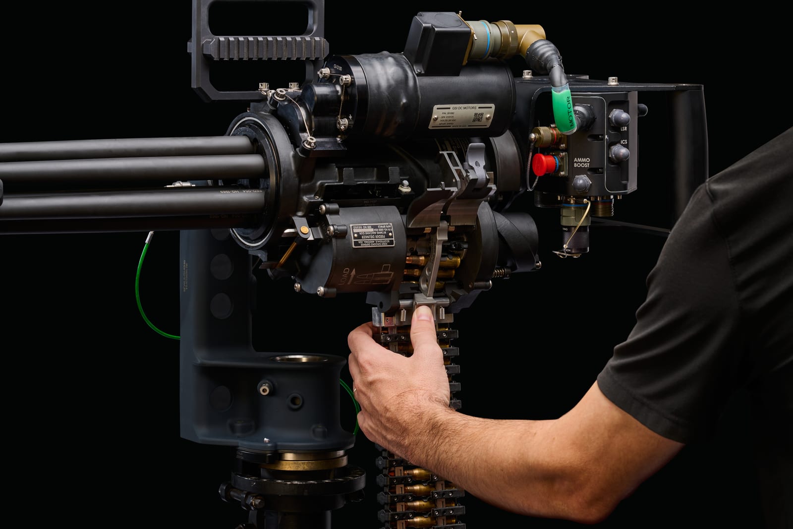 Technician handling the ammunition feed path on an M134HG system